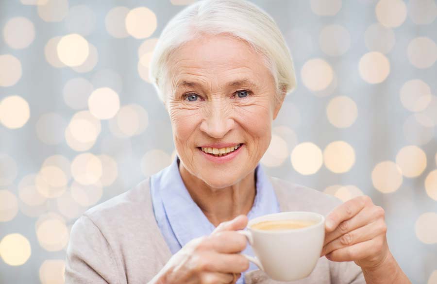 older woman smiling enjoying coffee